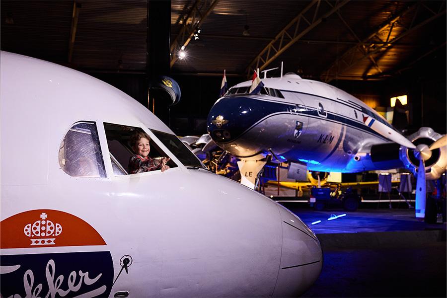 Kind in de cockpit van een vliegtuig op de grond in een museum