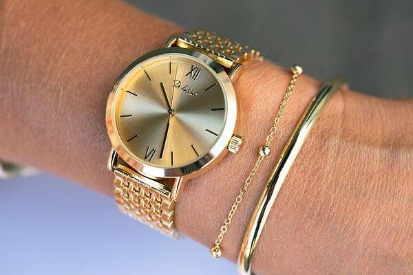 vrouwenpols met een goudkleurig horloge en 2 armbanden om