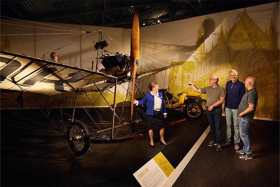 Museumbezoekers voor een oud vliegtuig