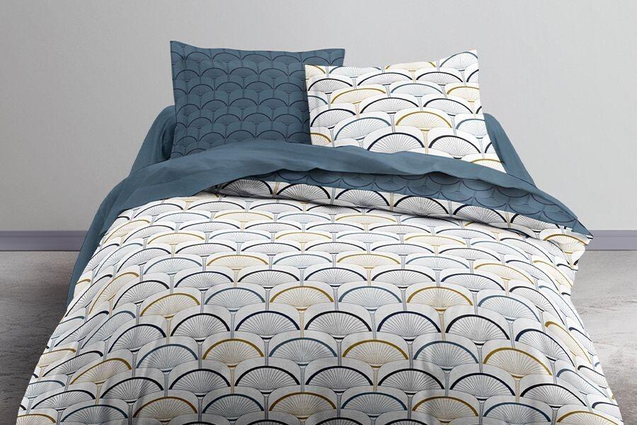 Dekbedovertrek met blauw en een print op een bed in een slaapkamer